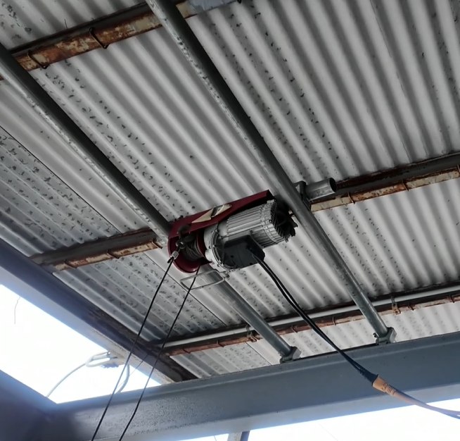 鉄骨から屋根方向へ立ち上げた単管パイプに、電動ウインチが吊り下げられている全体の様子
